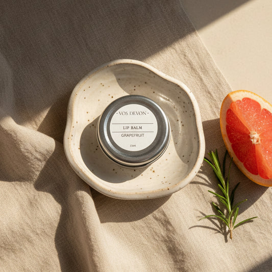 A round silver metal tin of VOS DEVON Lip Balm in Grapefruit scent