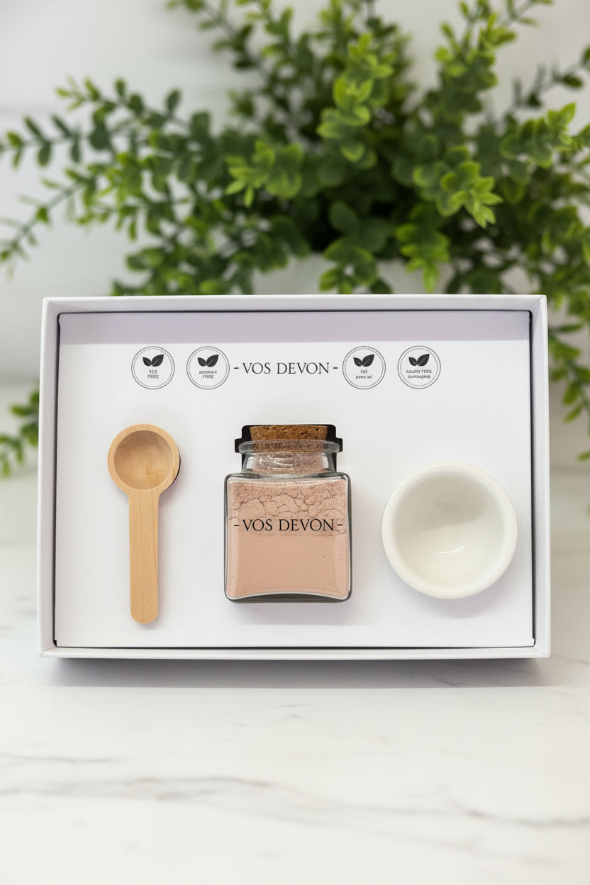 Set of a small bowl, bottle, and wooden scoop in a box on a wooden surface